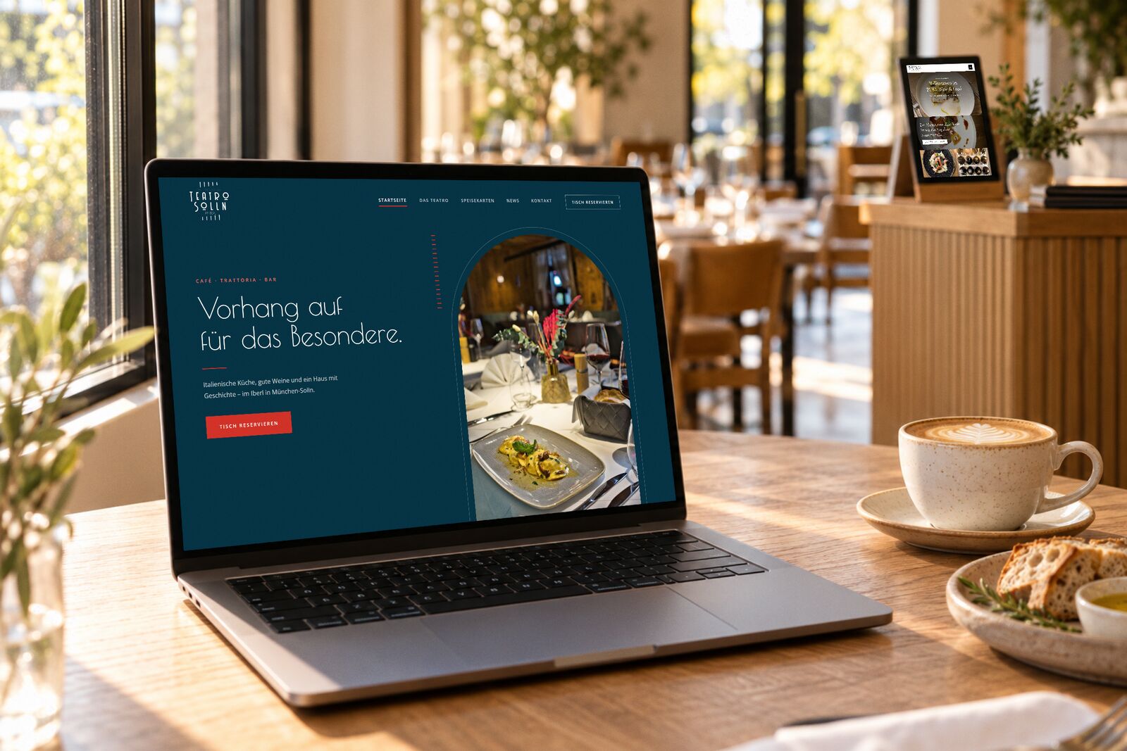 Restaurant-Website des Teatro Solln in München auf einem Laptop in einem hellen Gastraum