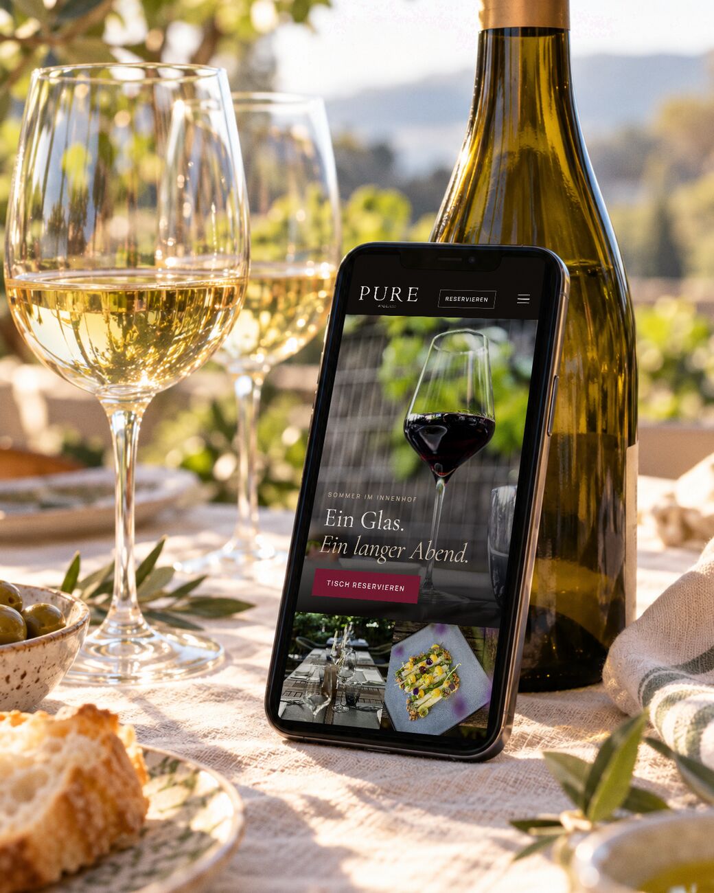 Fotografie von TasteWorks für PURE Wine & Food in München, als mobile Website inszeniert, auf dem Smartphone im Garten