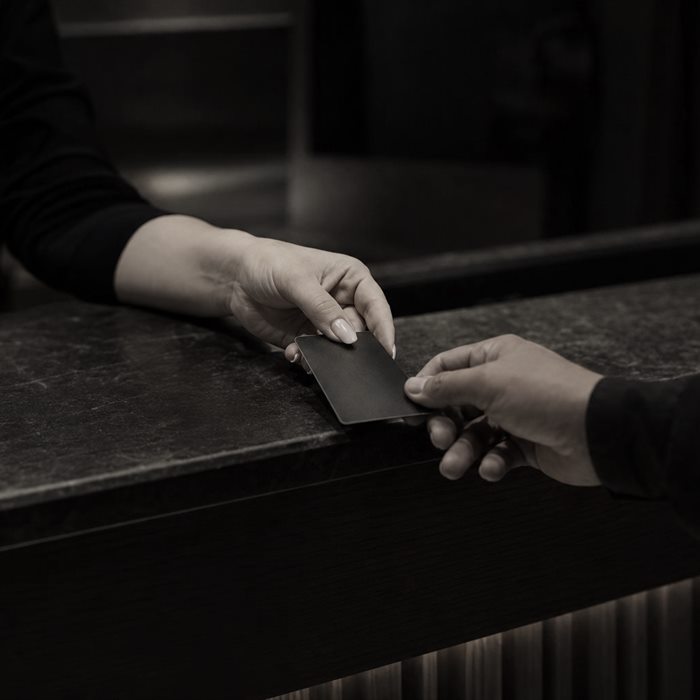 Übergabe der Zimmerkarte an der Rezeption eines Hotels