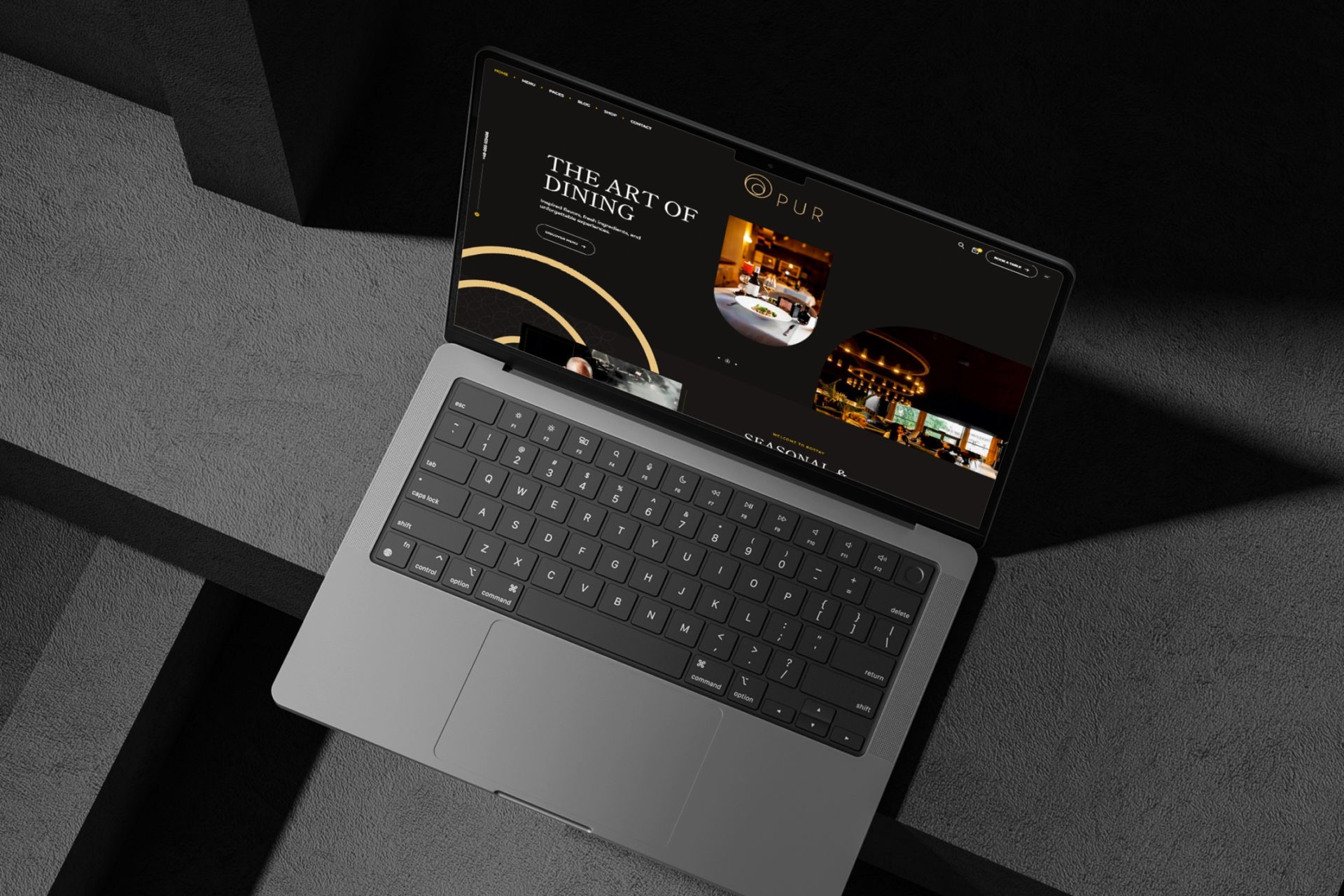 Website eines Restaurants auf einem Laptop, aufgestellt auf dunklem Beton