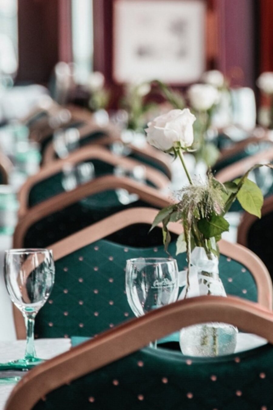Eingedeckte Tafel mit Gläsern und weißen Rosen im Restaurant Erhard in Regensburg