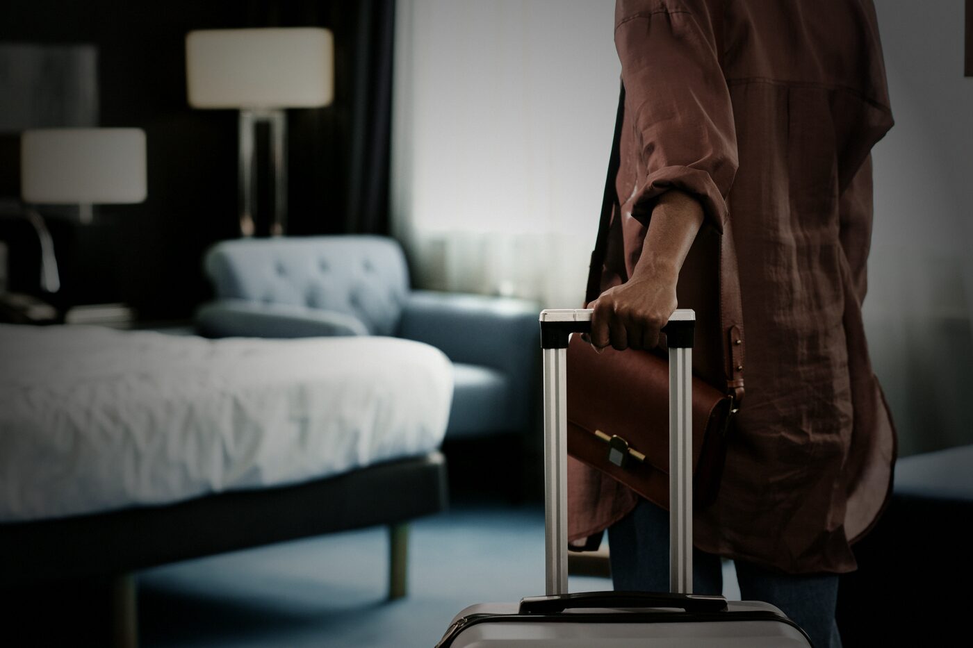 Gast kommt mit Koffer im frisch hergerichteten Hotelzimmer an