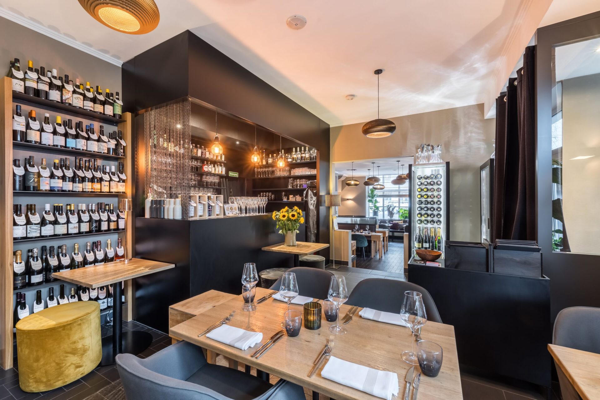 Gastraum mit Weinwand und Bar am Abend, PURE wine & food, München