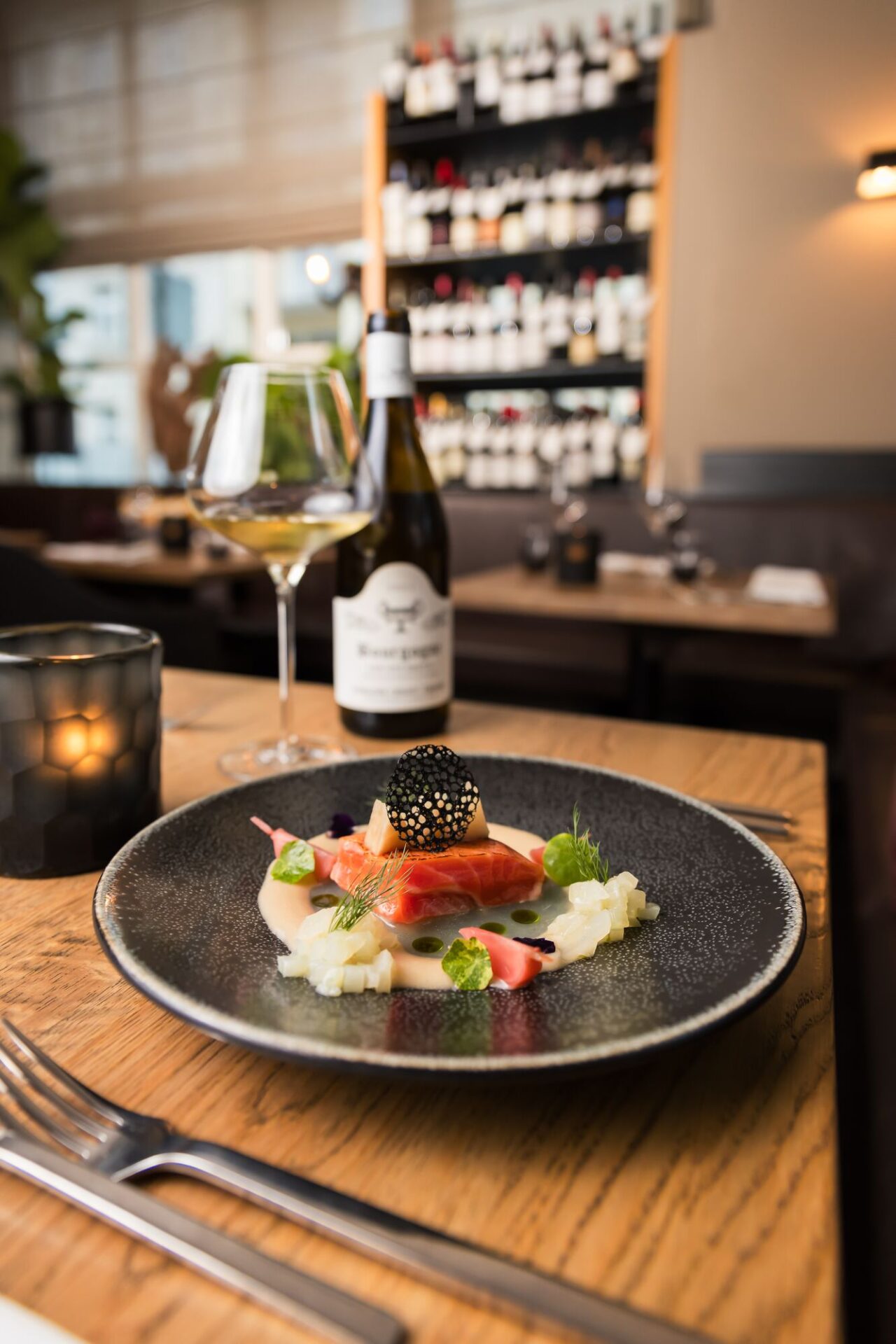 Lachs mit Kaviar und Weinbegleitung vor der Weinwand im PURE wine & food, München