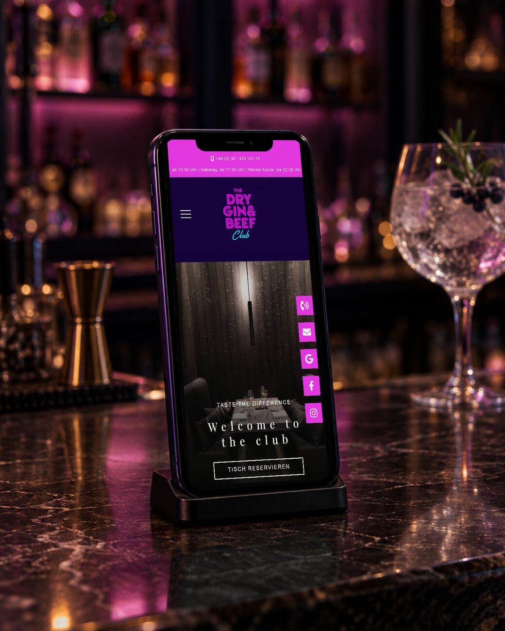 Restaurant-Website des Dry Gin & Beef Club in Berlin auf dem Smartphone am Bartresen