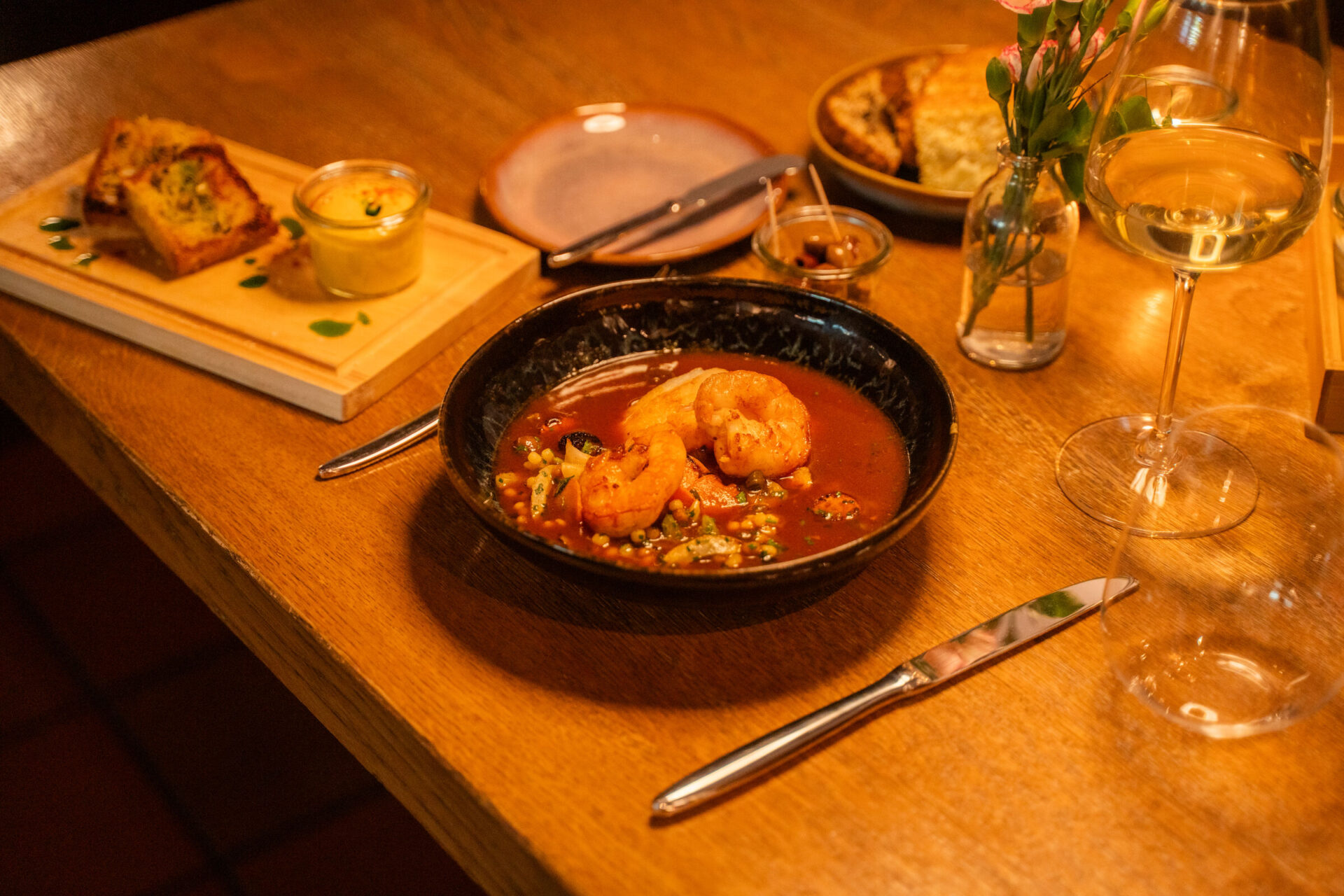 Garnelen im Sud mit Beilagen auf gedecktem Holztisch im Restaurant Brodersen, Hamburg-Rotherbaum